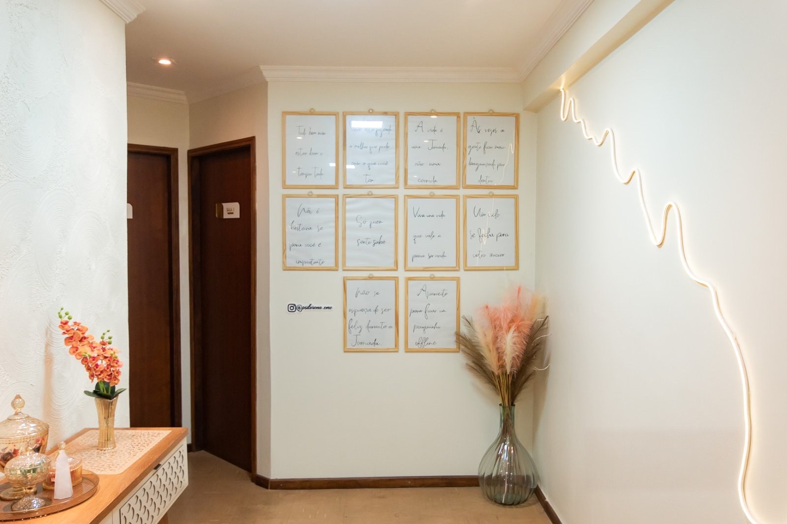 Sala de espera do consultório, com quadros na parede e um arranjo de flores.
